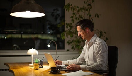 Adult man focused on work at his desk late in the evening Adult man focused on work at his desk late in the evening