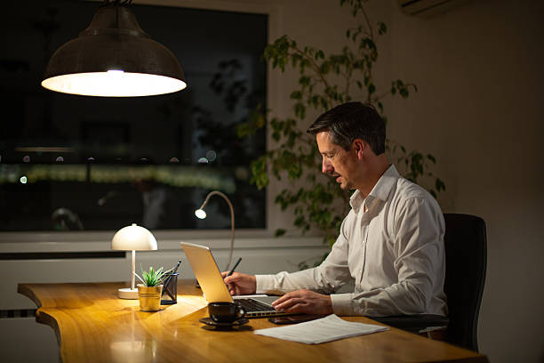 Adult man focused on work at his desk late in the evening